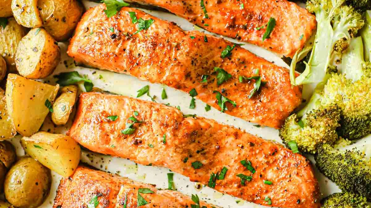 Lachfilets mit Rosenkartoffeln und Zitronenschnitzen auf einem Backblech